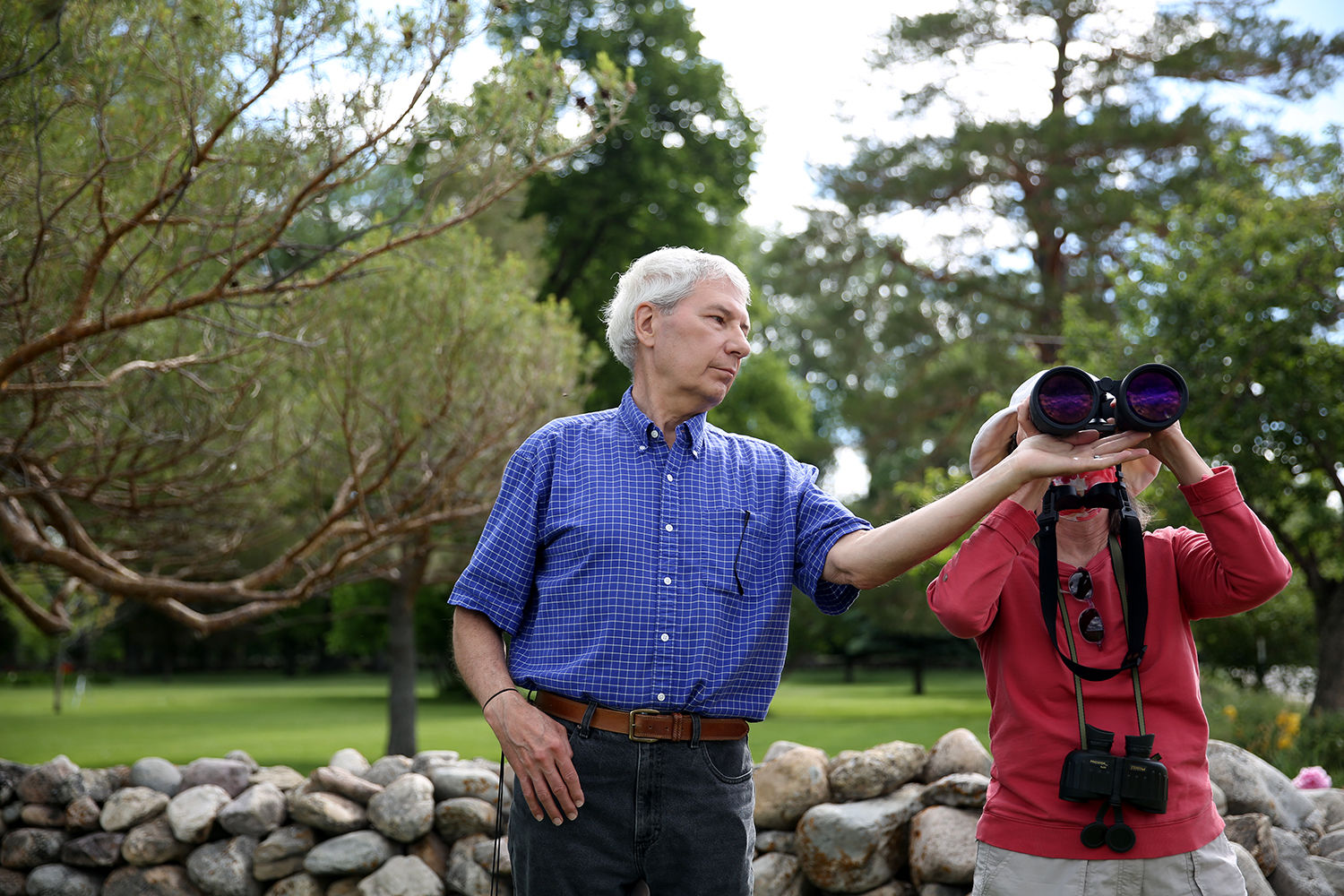 Rich Urbatchka helps hold up a large pair of binoculars for Sheila Flynn